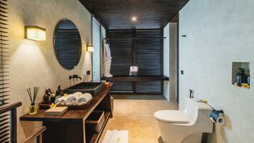 A modern bathroom with a bathtub, toilet, and a vanity with a mirror.