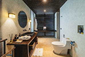 Un baño moderno con bañera, inodoro y tocador con espejo.