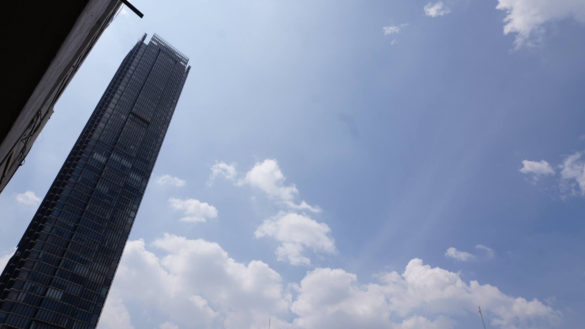 Ein hohes Gebäude vor blauem Himmel mit Wolken.