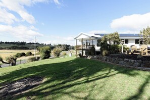 A house with a covered porch, solar panels, and a well-maintained lawn. - Tranquillity and the Tamar Valley at your doorstep (Legana)