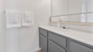A bathroom with a white sink, a mirror, and two towels hanging on the wall. - Stylish Mesa 2BR • Perfect for ASU Visits (Mesa)