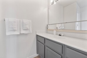 A bathroom with a white sink, a mirror, and two towels hanging on the wall. - Stylish Mesa 2BR • Perfect for ASU Visits (Mesa)