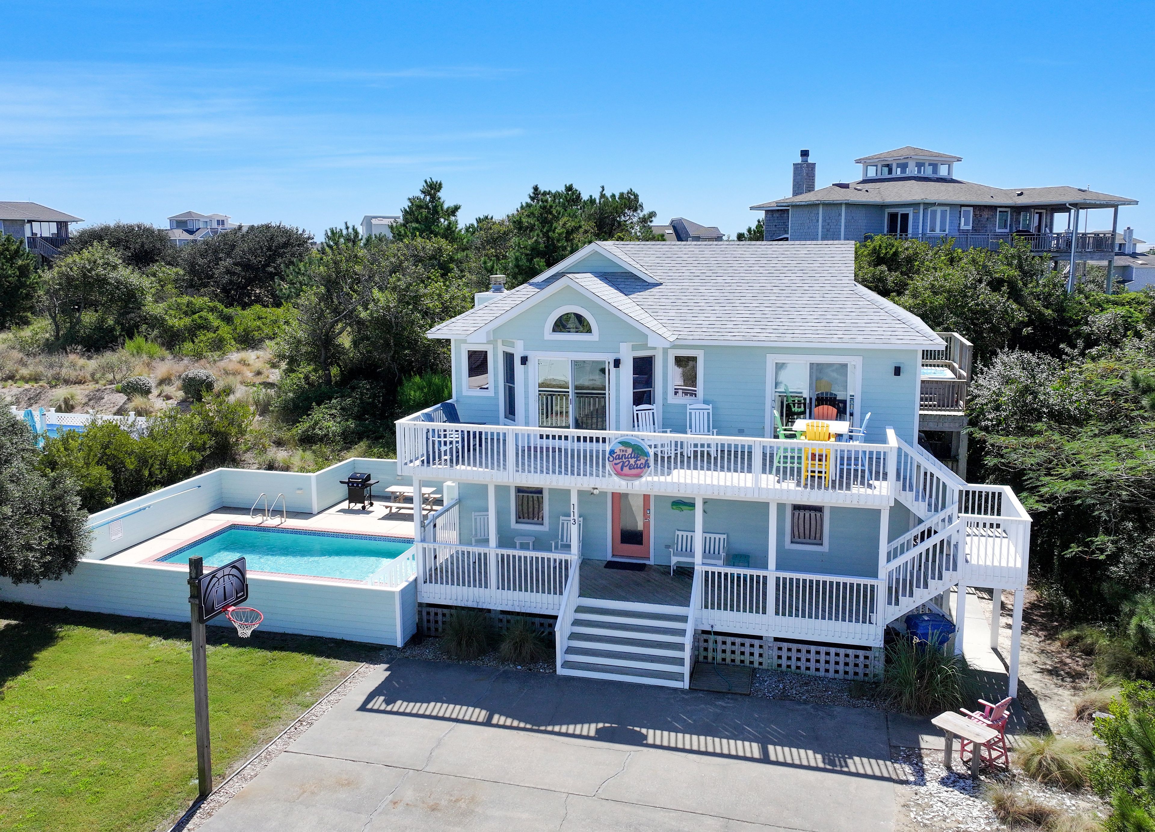 Una casa de dos pisos con balcón, piscina y terraza.