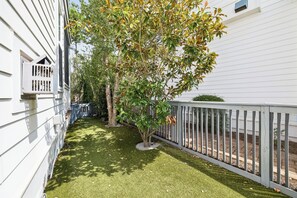 A residential property with a white exterior, a fenced yard, and a tree with green and yellow leaves. - 🐚 Gone Coastal | Private Heated Pool + Hot Tub | Bikes | Fire Pit (Santa Rosa Beach)
