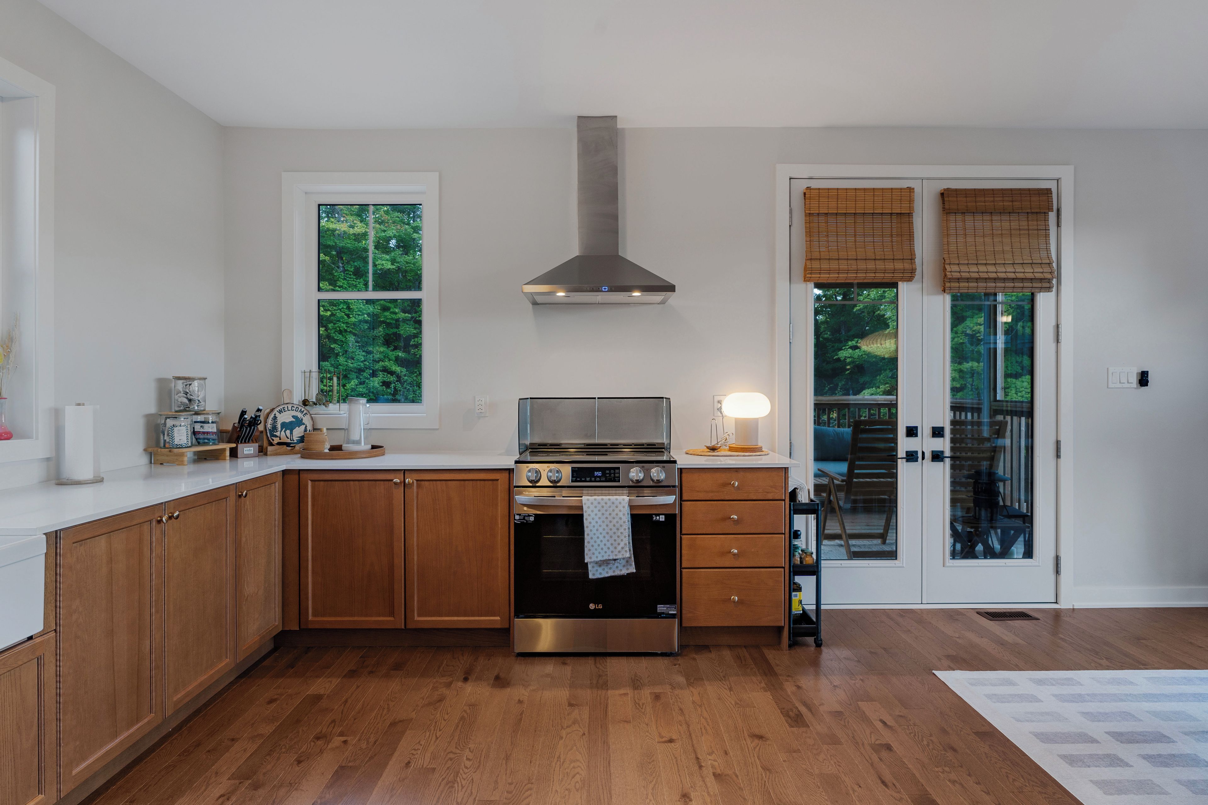 Una cocina moderna con armarios de madera, estufa de acero inoxidable y horno empotrado.