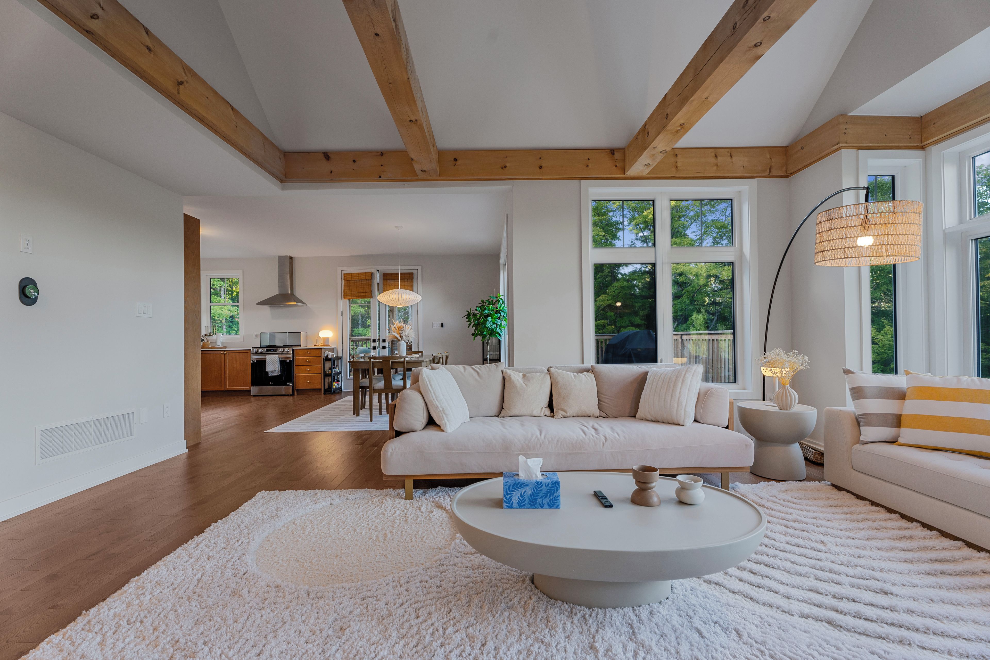Ein modernes Wohnzimmer mit einer Couch, einem Couchtisch und einem Essbereich im Hintergrund.