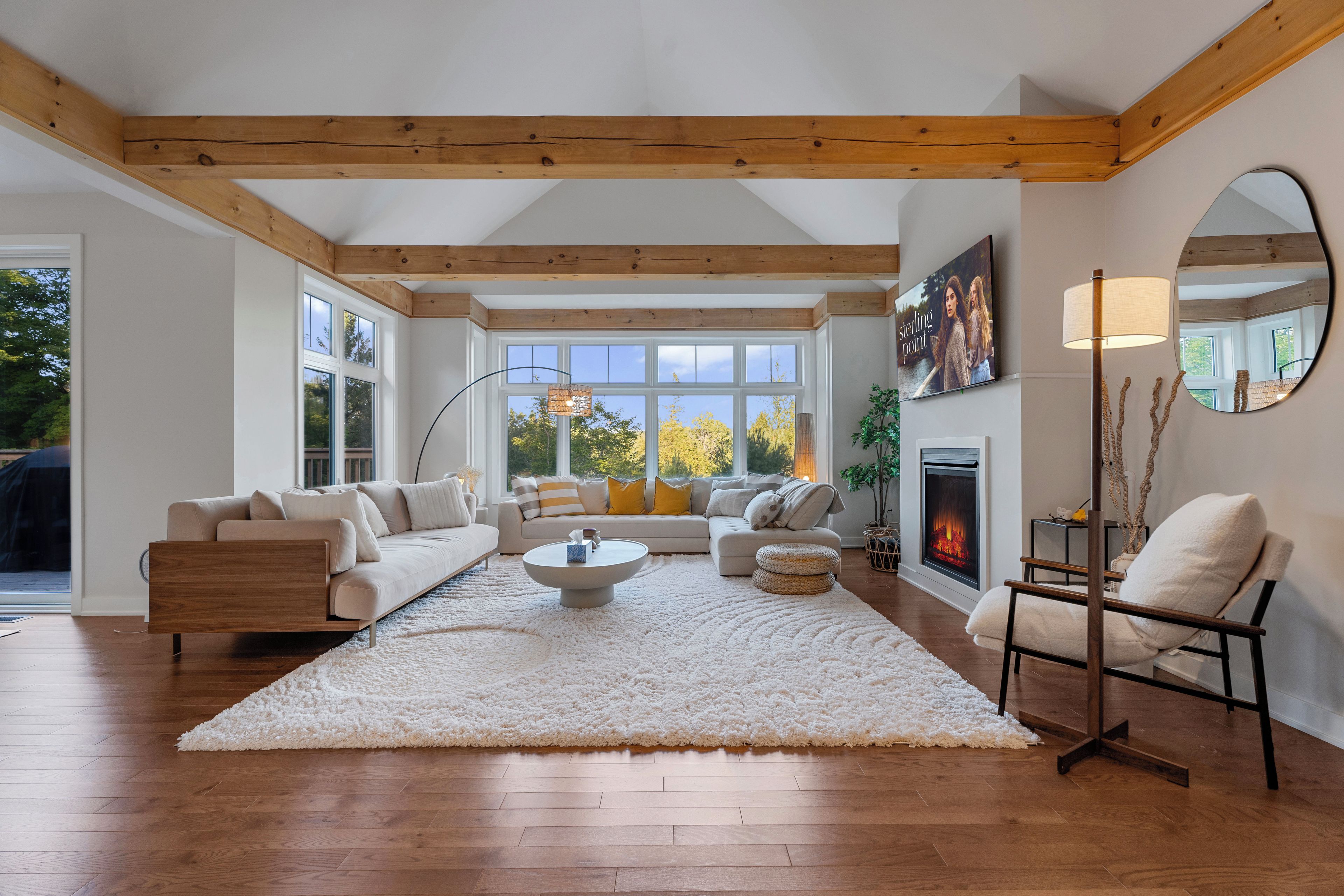 A spacious living room with a fireplace, a large window, and a cozy seating area.