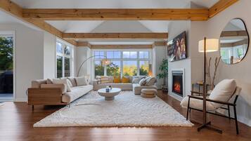 A spacious living room with a fireplace, a large window, and a cozy seating area.