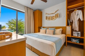 A hotel room with a large bed, a wooden wardrobe, a vanity with a mirror, and a view of the outdoors. - Rooftop Pool & Beach Club Condo, Walking Distance to Marina & Beach, Sleeps 6 (Bahia de Banderas)