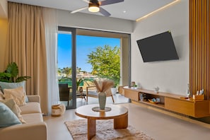 Uma sala de estar moderna com um sofá, mesa de centro e televisão de tela plana na parede.