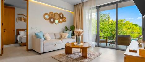 Un salon moderne avec un canapé, une table basse et une vue sur la verdure à l’extérieur.