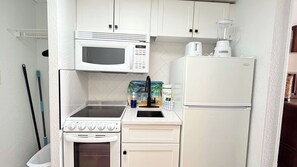 A compact kitchenette with a microwave, toaster, and small oven. - Sunny Oceanfront Studio + pool (Myrtle Beach)