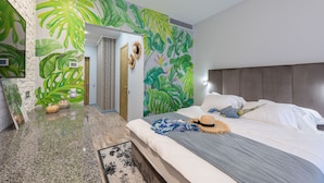 A modern bedroom with a large bed, a headboard, and a tropical leaf mural on the wall. - Playwright Test Hotel 1789175829844 (Seattle)