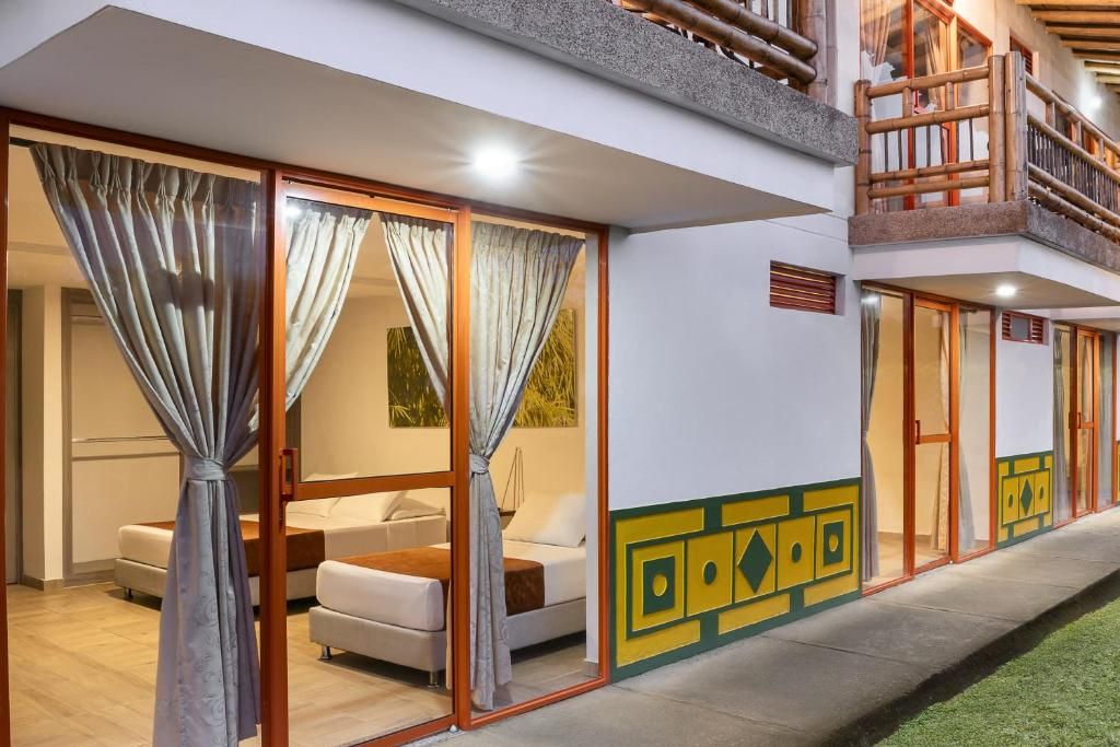Habitación de hotel con cama, sofá y un amplio ventanal corredero.