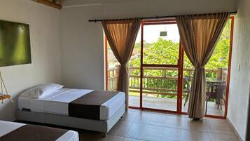 Een kamer met twee bedden, een balkon met uitzicht en een schuifdeur.