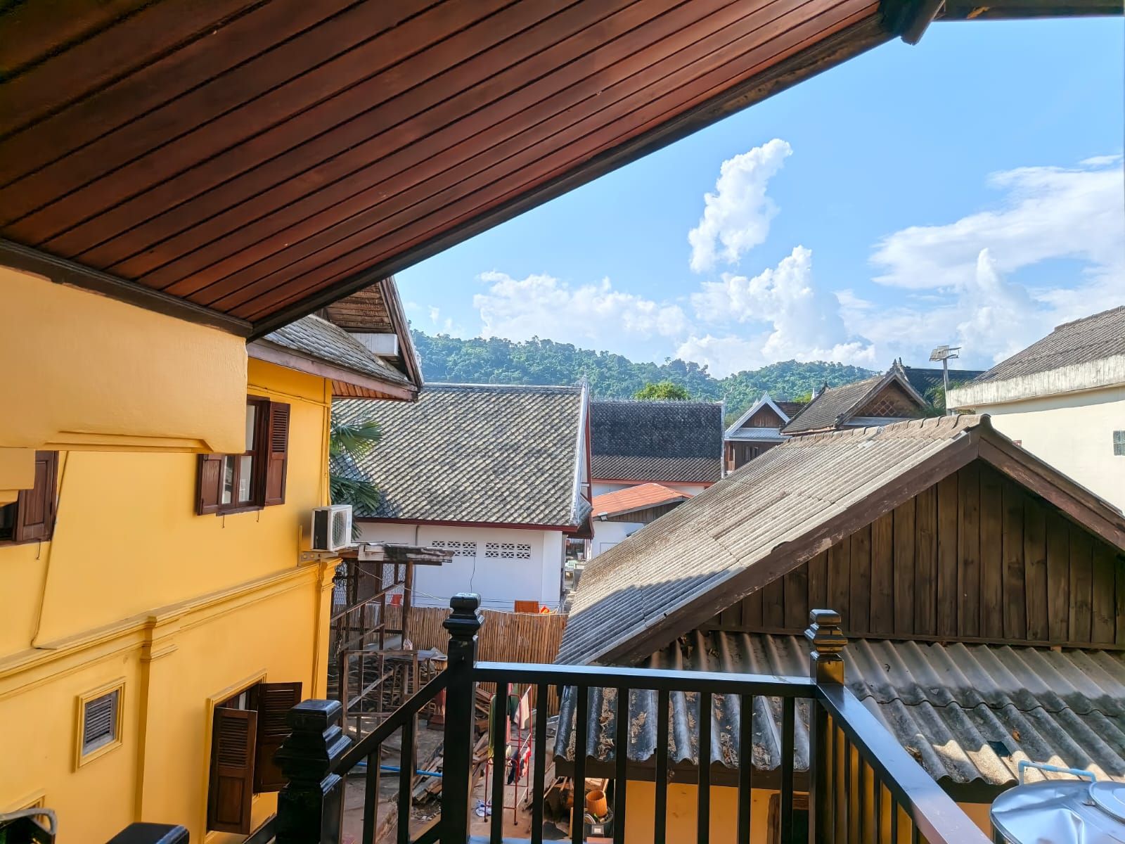 A balcony with a view of traditional buildings and a clear sky.