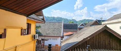 A balcony with a view of traditional buildings and a clear sky.
