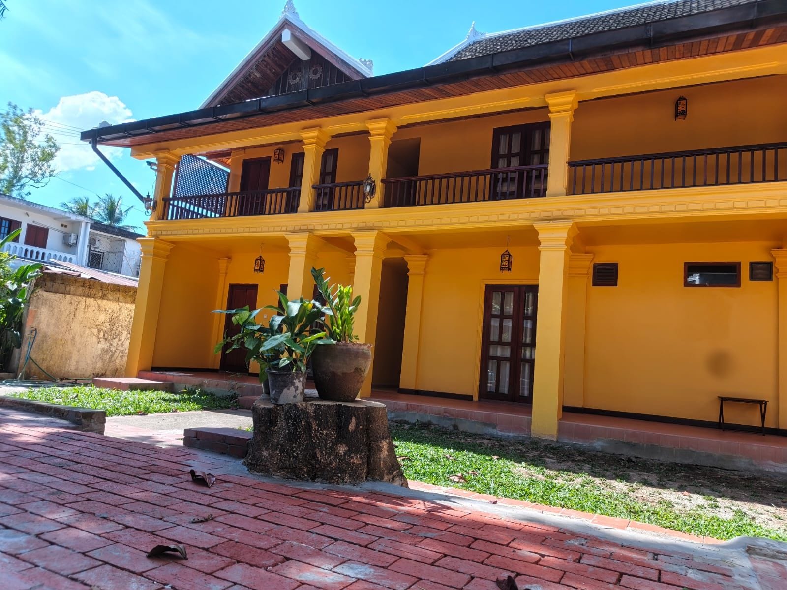 A two-story building with a yellow facade, multiple windows, and a balcony.