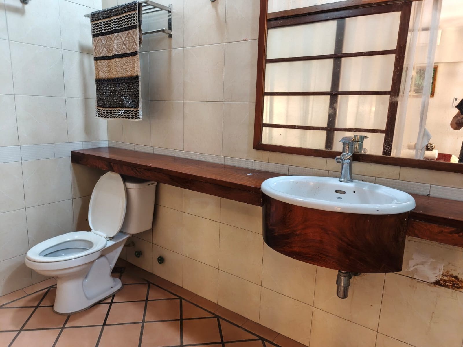 A bathroom with a toilet, a sink, and a window.