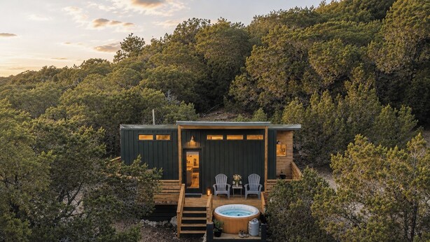 Uma cabana com hidromassagem, área de estar externa e um deck.