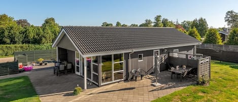 A covered outdoor area with a patio, seating, and a view of the surrounding landscape.