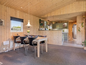 A wooden interior with a dining area, kitchen, and a view of the outdoors. - "Fabian" - 300m from the sea by Interhome (Børkop)