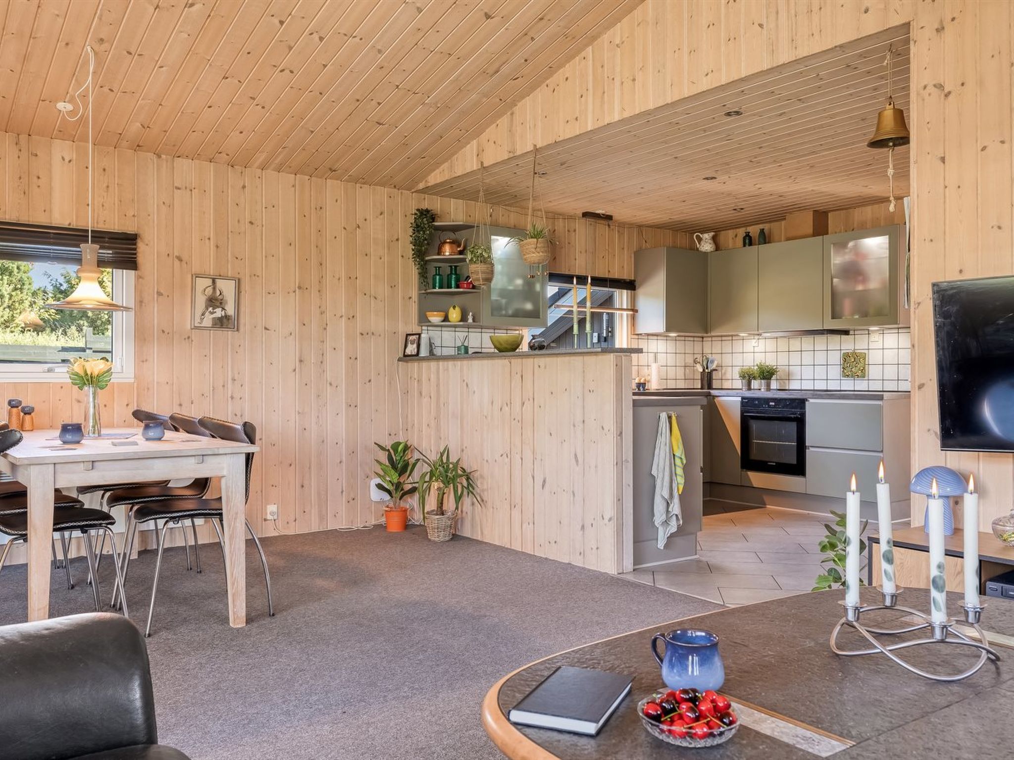 A wooden interior with a dining area, kitchen, and living space.