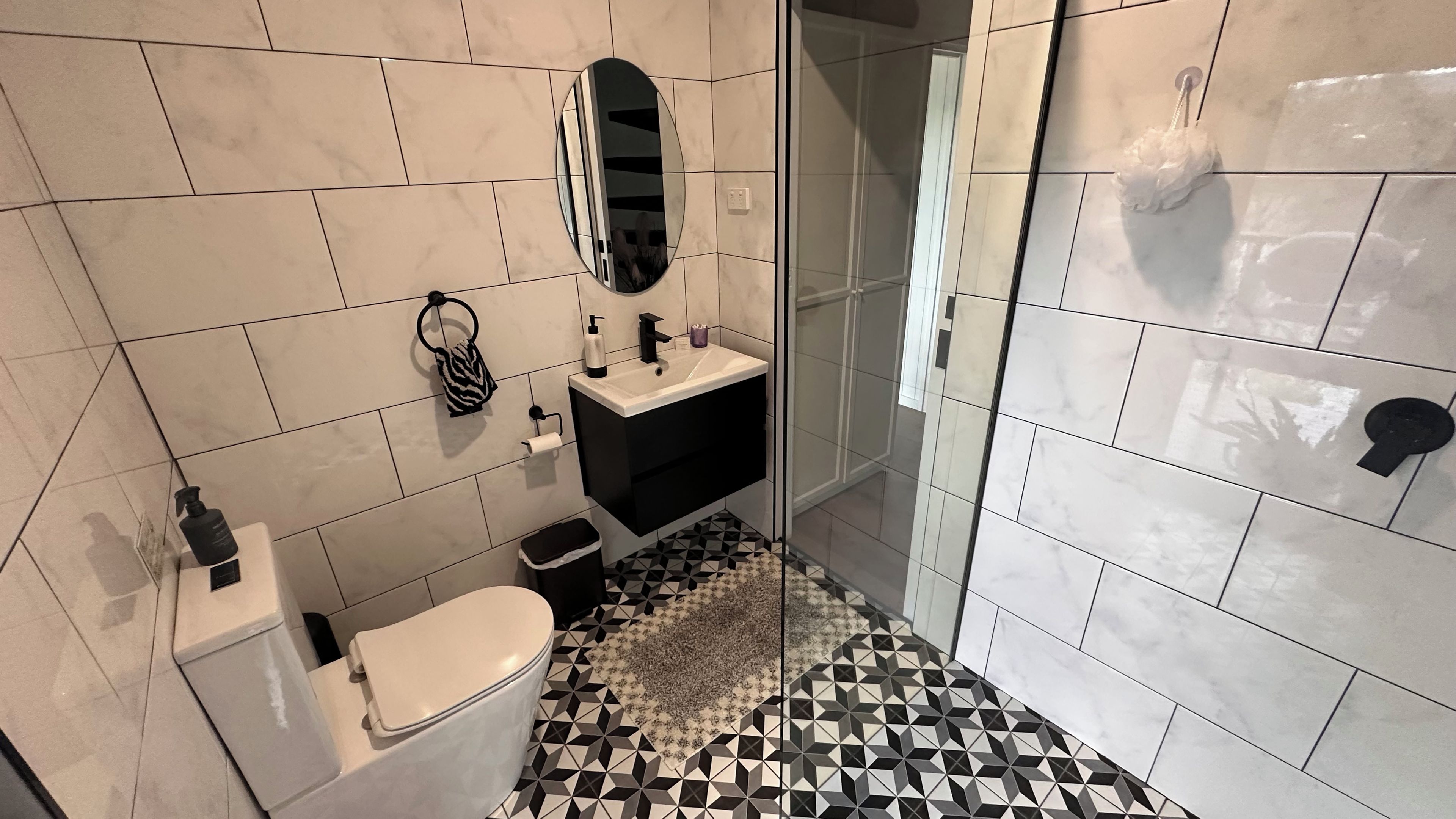 A bathroom with a toilet, sink, and shower.