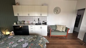 Ein kompakter Wohnbereich mit Küchenzeile, Essplatz und Bett.