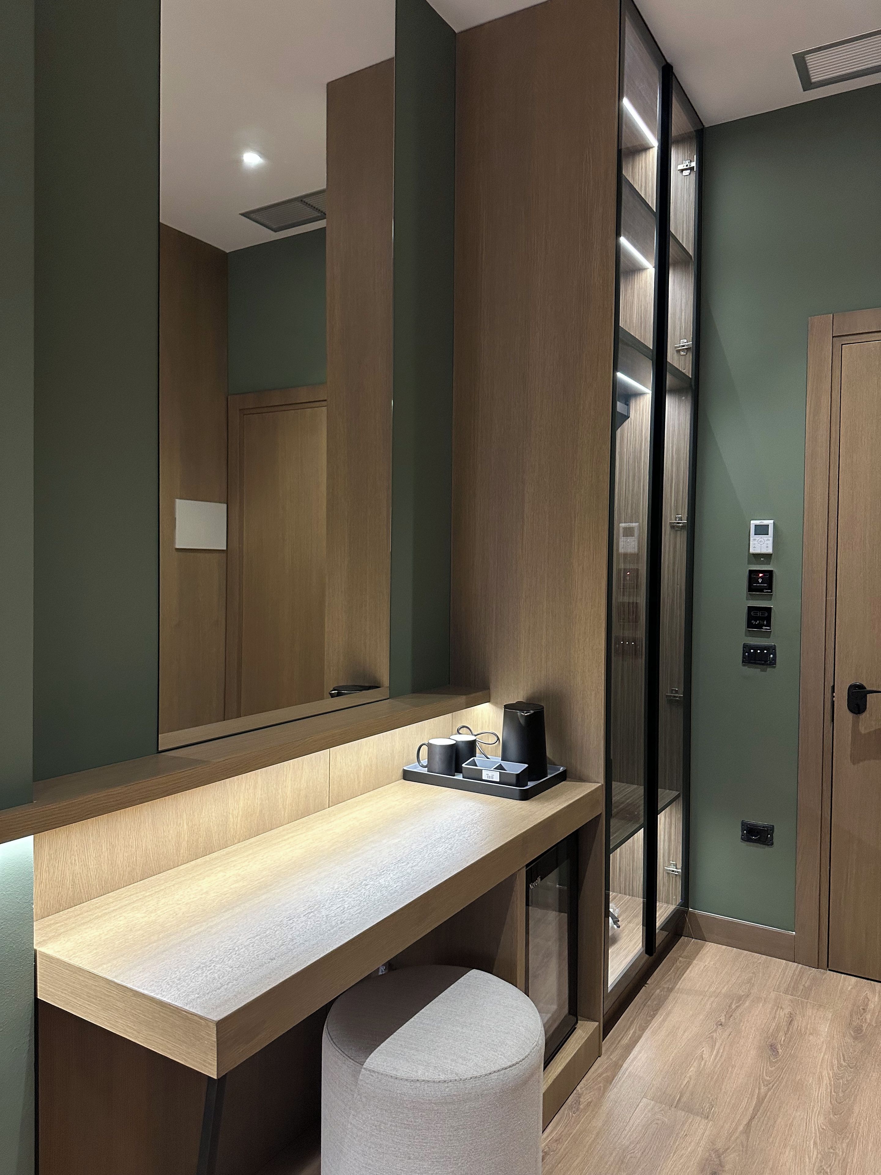 A modern bathroom with a wooden vanity, a mirror, a towel, and a toilet.