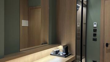 A modern bathroom with a wooden vanity, a mirror, a towel, and a toilet.
