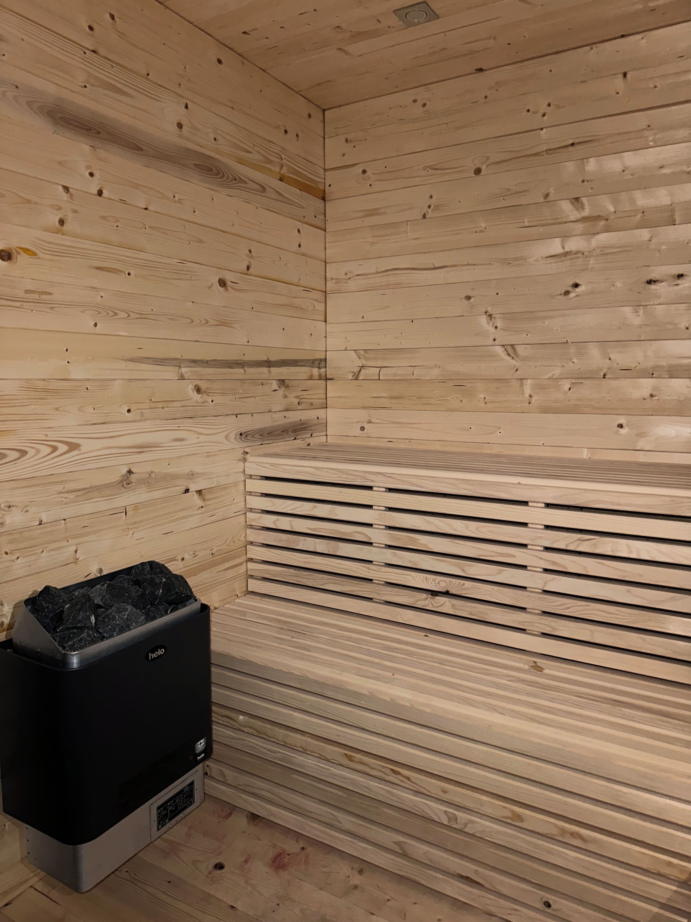 Un sauna con paredes de madera y un banco.