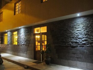 A building facade with stone walls and illuminated windows.