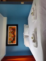 Una habitación de hotel con cama, toallas y un cuadro enmarcado en la pared.