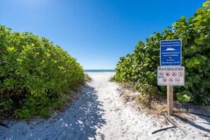 A beach path with a sign indicating beach regulations and a clear view of the ocean. - Completely Renovated, Private Dock & Beach days, bay views! (Holmes Beach)