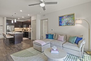 A modern living space with a kitchen, a dining area, and a seating area with a sofa and a coffee table.