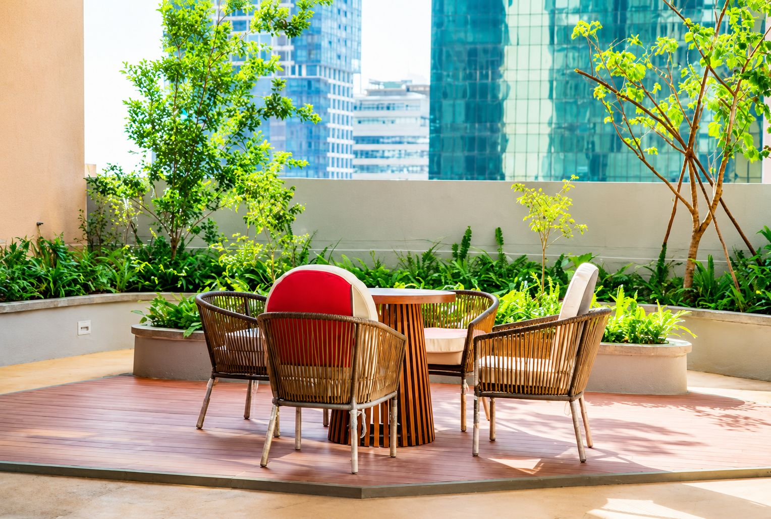 A terrace with wicker furniture, a round table, and potted plants.