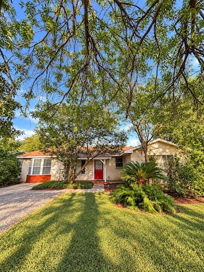 A single-story house with a red front door, a brick exterior, and a well-maintained lawn. - Howdy, San Antonio! Cozy 3BR• Sleeps 8 • 5 Mins From Airport (San Antonio)