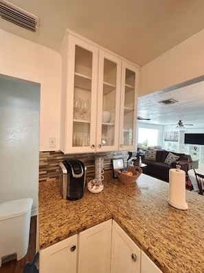A kitchen with white cabinets, a granite countertop, and a coffee maker. - Howdy, San Antonio! Cozy 3BR• Sleeps 8 • 5 Mins From Airport (San Antonio)