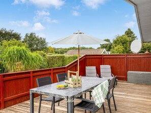 An outdoor patio with a table, chairs, and a large umbrella. - "Laurine" - 500m from the sea by Interhome (Sydals)