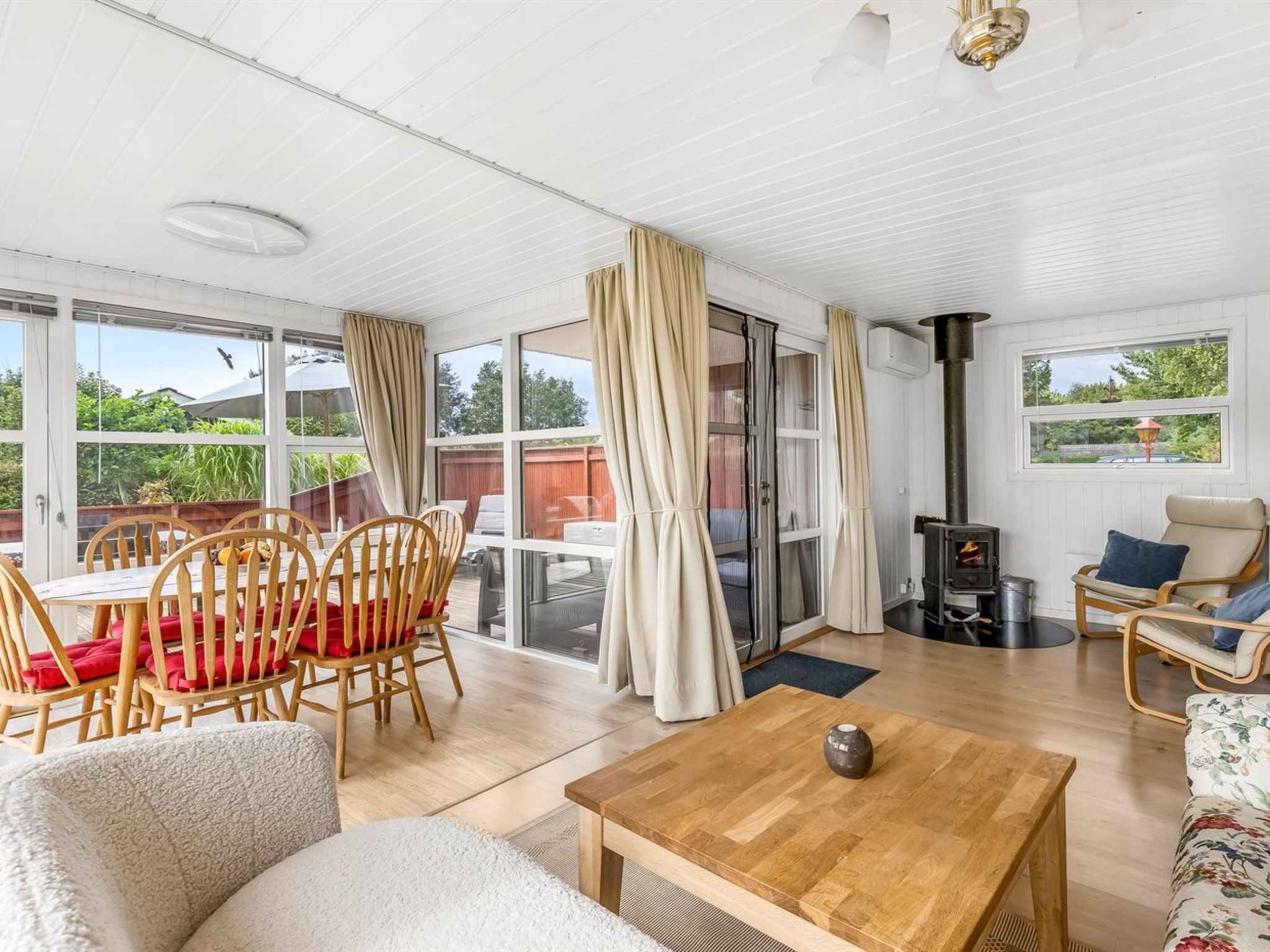 Ein geräumiges Zimmer mit Holztisch, Stühlen, einer Couch und einem Kamin.