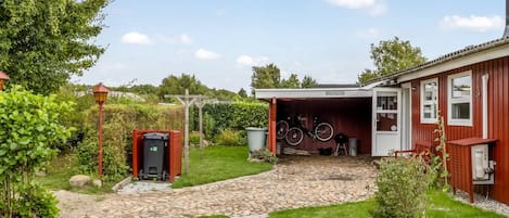 A residential property with a garage, a pathway leading to the entrance, and a small garden area.