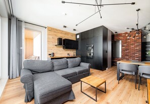Ein modernes Wohnzimmer mit einer Eckcouch, einem Holztisch und einem Essbereich mit Tisch und Stühlen.