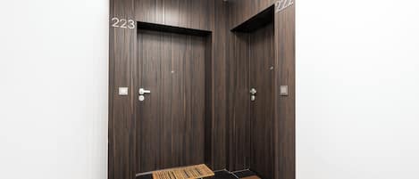 A modern elevator with dark wood paneling and numbered doors 223 and 224.