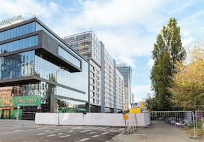 Un edificio moderno con amplios ventanales y un cartel que dice 'Blisko 3 Miliony Klientów'.
