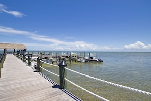 A wooden pier extending into calm waters, with a thatched-roof structure at the end. - Ocean-front 2BR condo in Islamorada with pool, hot tub, gym, and balcony. (Islamorada)