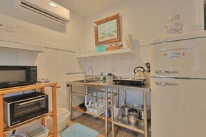 A compact kitchen with a microwave, toaster oven, and a refrigerator. - Beach Tree Cottage,Walk To Beach& Siesta (Siesta Key)