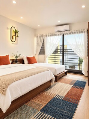 A modern bedroom with two beds, a large window with sheer curtains, an air conditioning unit, and a decorative wall light. - Aura Retreat Hanoi Central (Ha Noi)