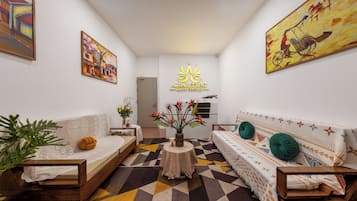 A modern living room with a sofa, a coffee table, and a painting on the wall.