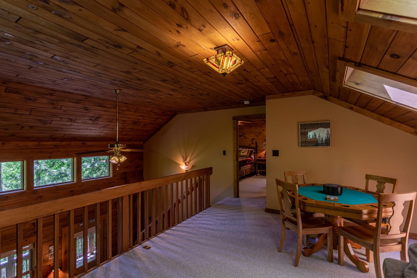 A wooden interior with a dining area, a staircase, and a view of the outdoors.